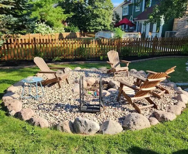 Completed outdoor firepit seating area with stone surround.