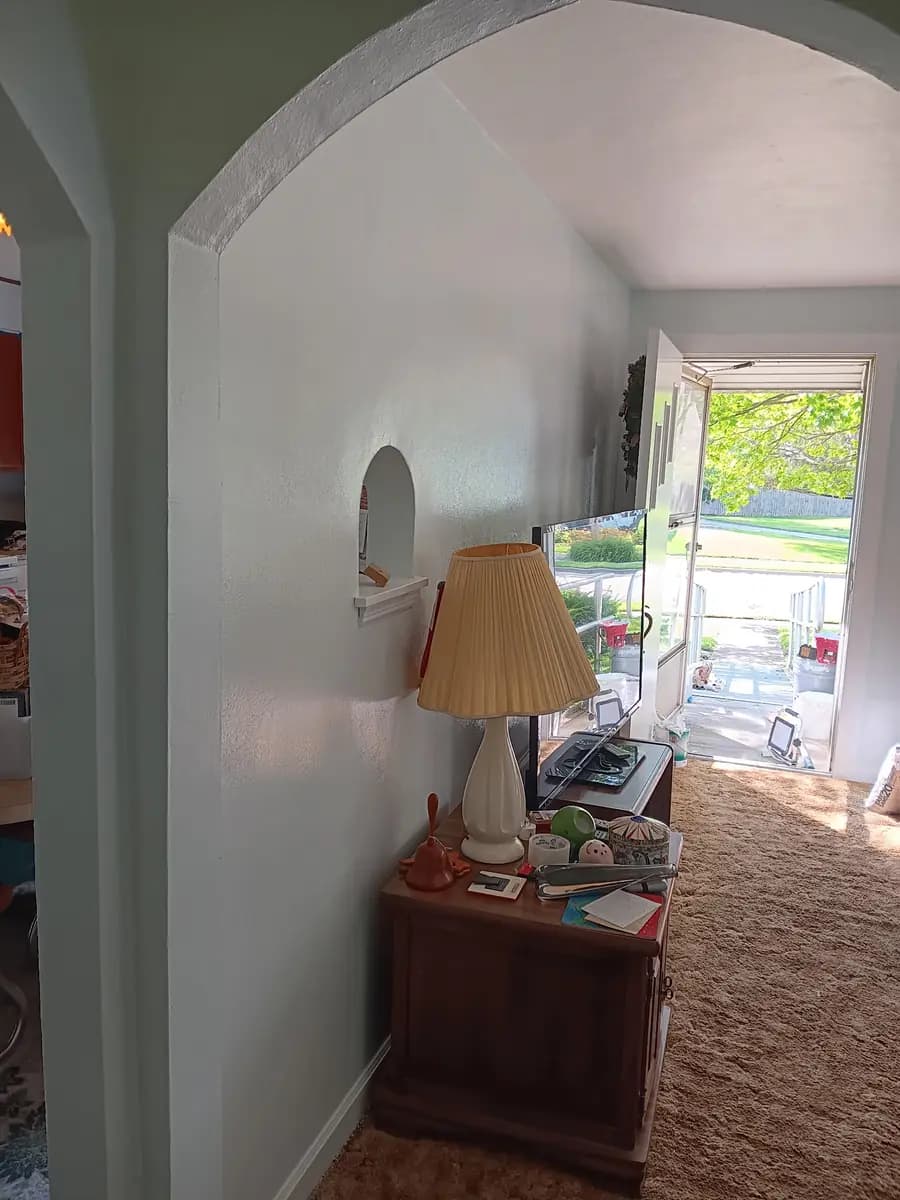 Repainted living area walls viewed through the arched doorway.