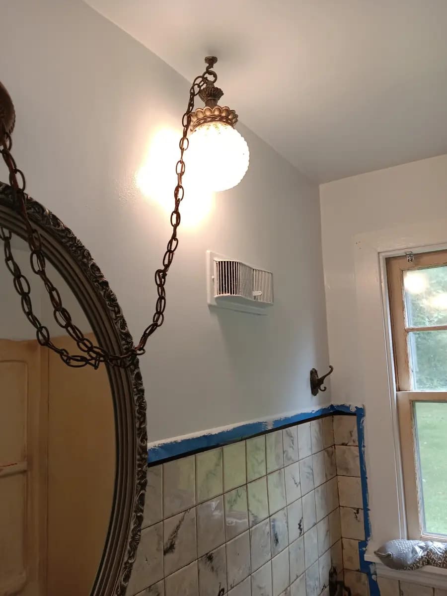 Vanity mirror and light fixtures with the newly painted wall color behind them.