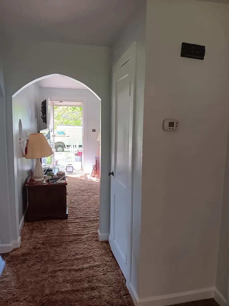 Finished hallway view showing the repainted arch and walls.