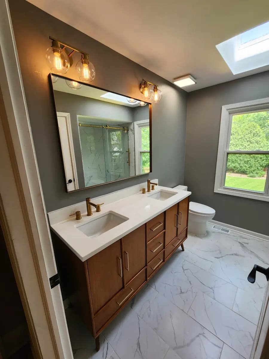 Wide view of the completed double vanity and brass lighting.