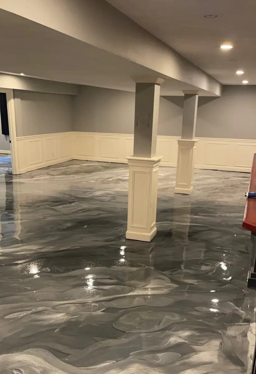 Basement room with a completed dark metallic epoxy floor.