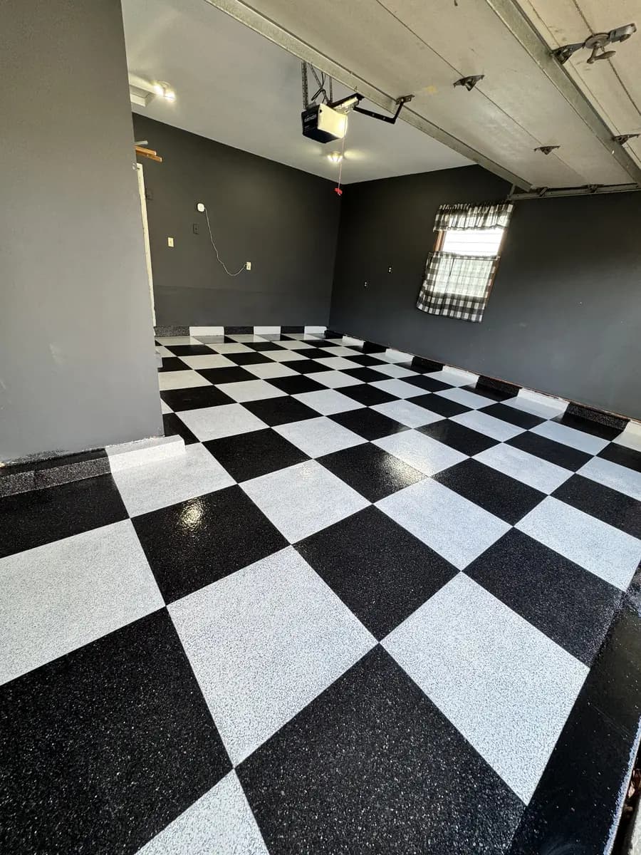 Garage with a completed black-and-white checkerboard epoxy floor.