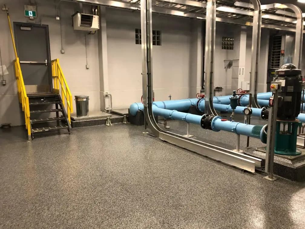 Mechanical room with a completed flake epoxy floor around utility equipment.