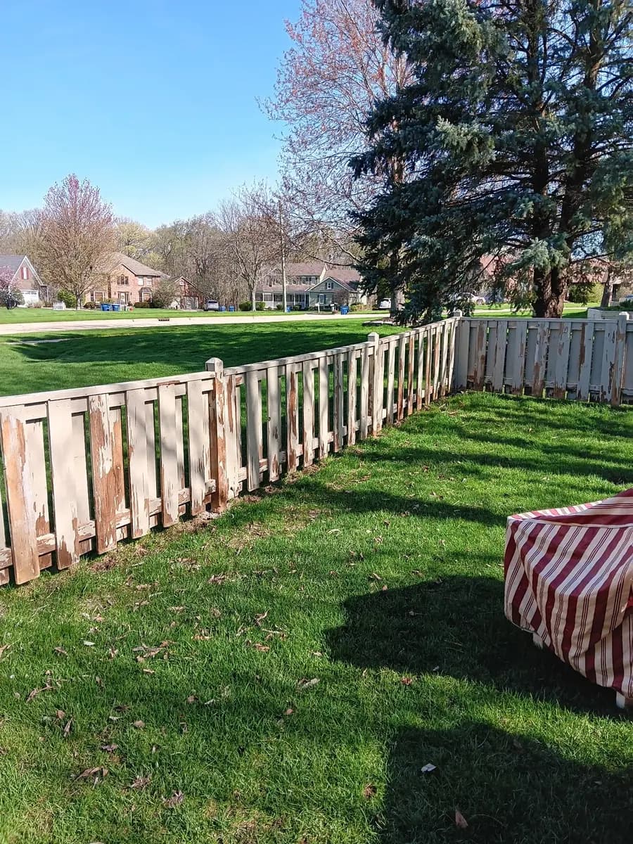 Fence before refinishing, showing weathered wood and uneven color.