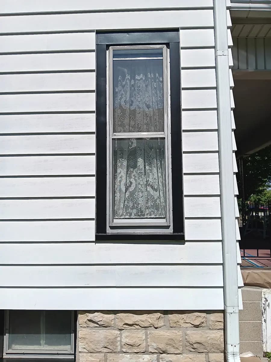 Repainted black window trim against the refreshed siding.
