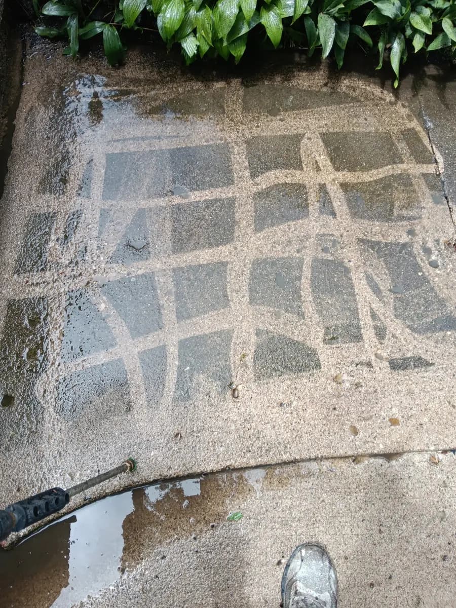 Concrete surface midway through pressure-washing.