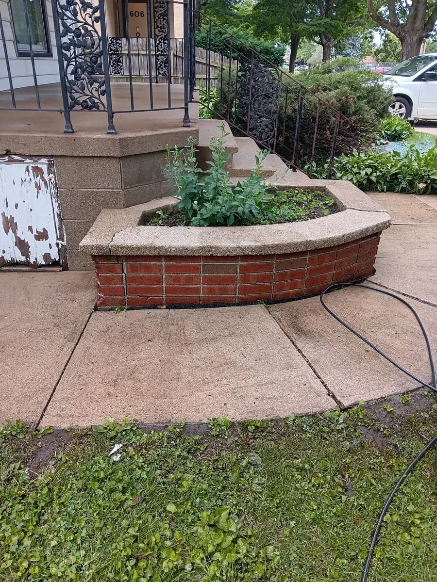 Cleaned entry planter and walkway beside the restored railing.